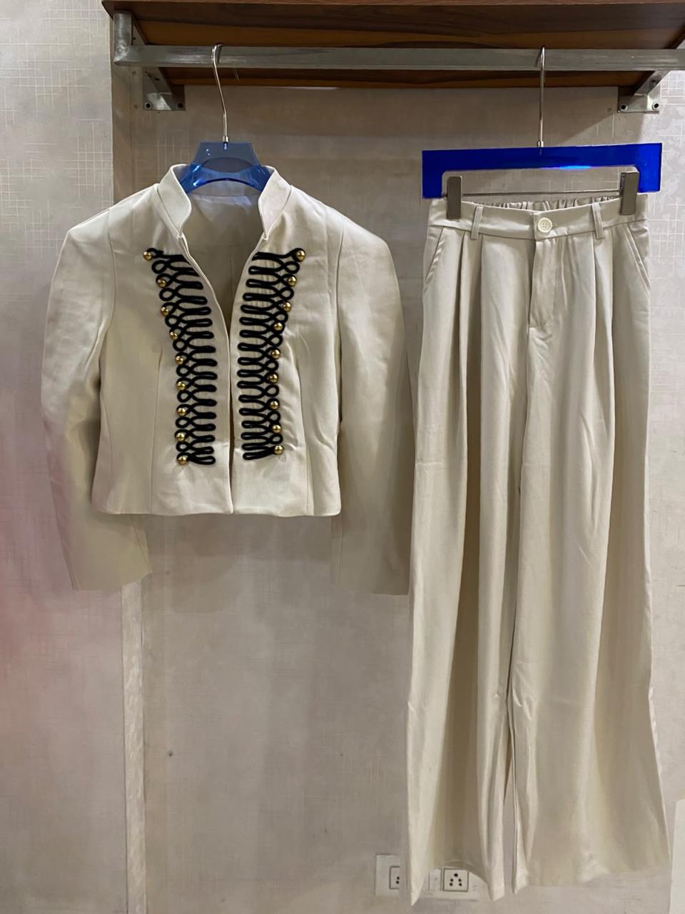 Elegant  off-white two-piece set with a military-inspired cropped jacket accented by black braiding and metallic buttons FT954