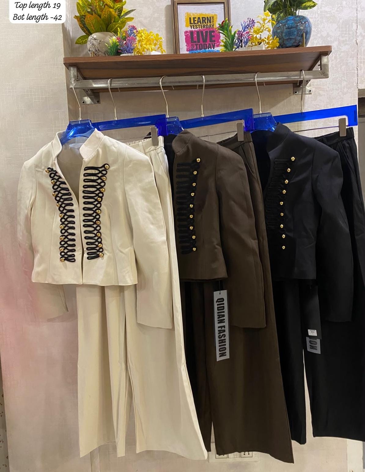 Elegant  off-white two-piece set with a military-inspired cropped jacket accented by black braiding and metallic buttons FT954